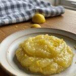 Realistic photo of Italian Lemon Spread Delight on a rustic plate, casually presented in a cozy home setting with natural light, featuring crumbs and imperfect plating, emphasizing an authentic homemade dessert experience.